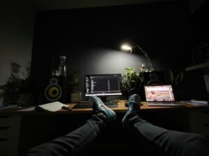 Person sitting at a home office desk working on a laptop