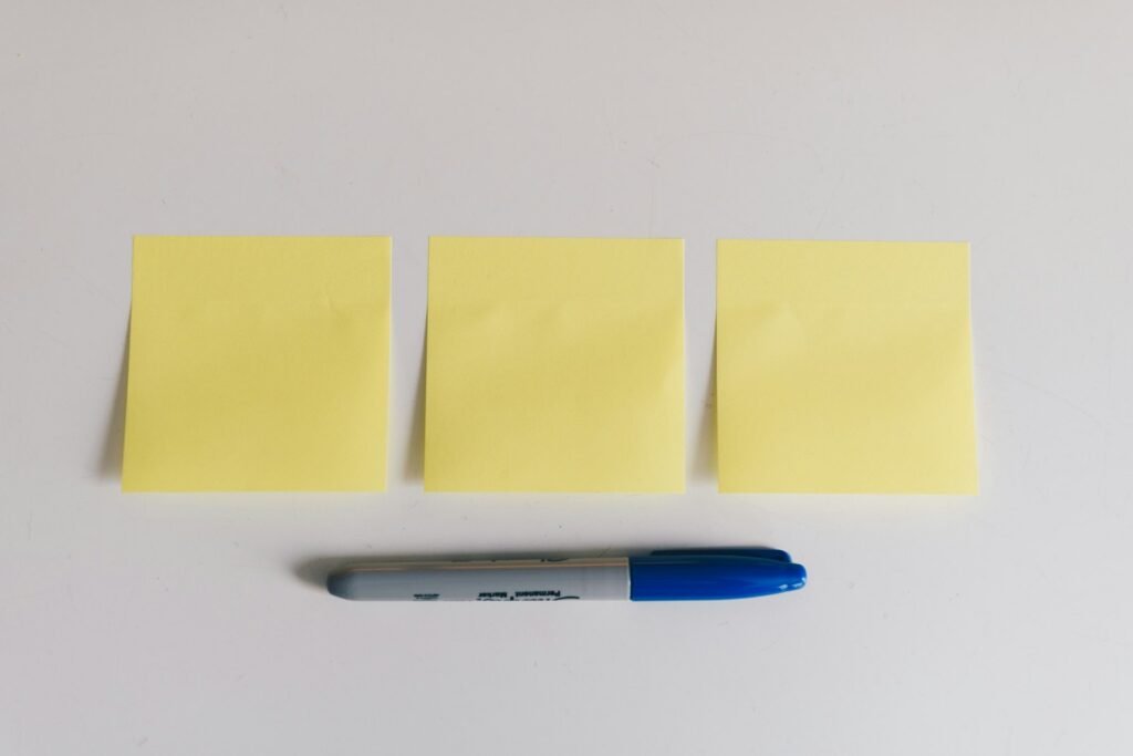 Best sticky note holders for a home office desk with yellow sticky notes and a marker