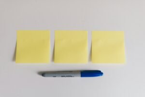 Best sticky note holders for a home office desk with yellow sticky notes and a marker