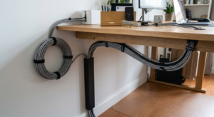 Braided cable sleeves routing cords along a desk in a home office