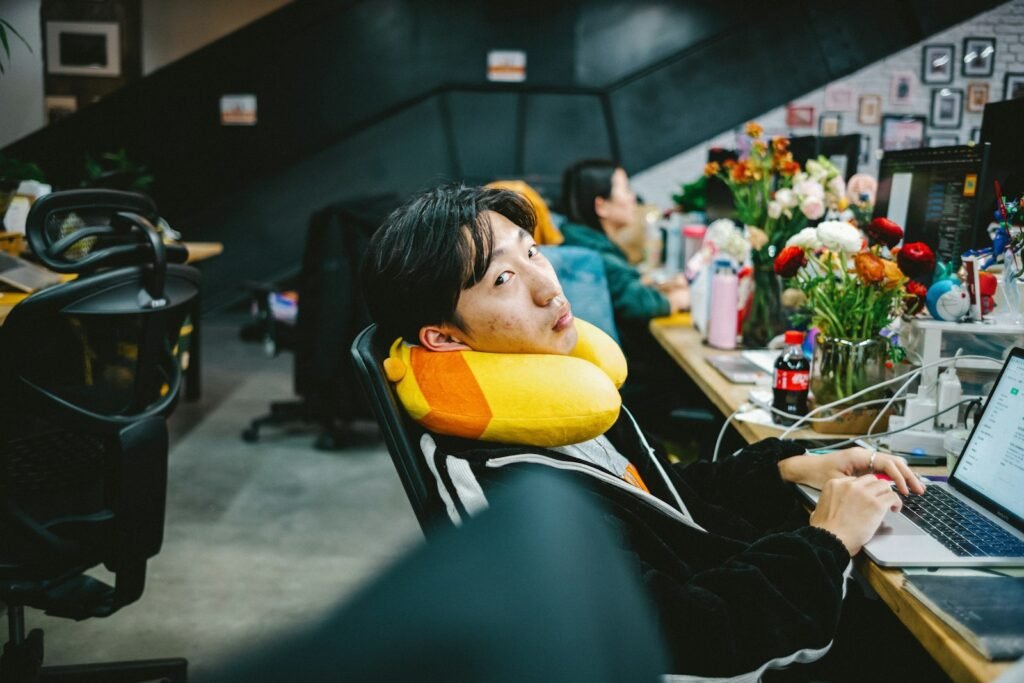 Person at a desk resting their neck on a travel neck pillow